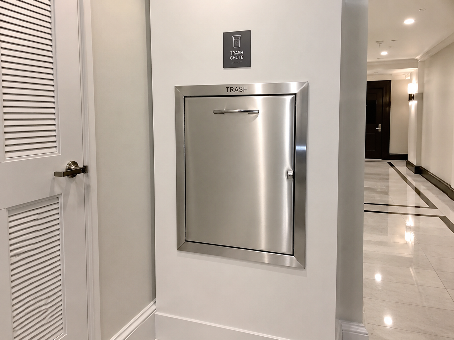 Clean stainless steel trash chute door with posted room guidance